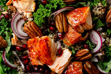 Salmon superfood salad background with grilled fish, kale, quinoa, pecan nuts, red onion and...