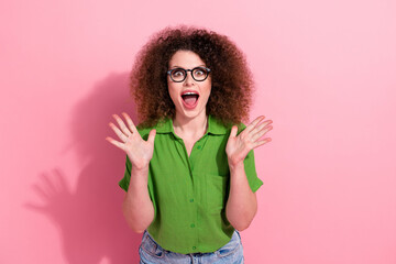 Photo portrait of attractive young woman raise arms open mouth impressed scream wear trendy green clothes isolated on pink color background