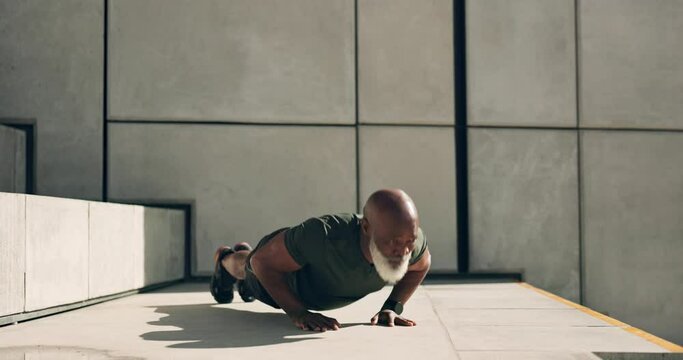 Mature man, training and fitness with pushup for strength, health or endurance with energy. African, person and alone in concentration for workout with exercise, strong and wellness near stairs