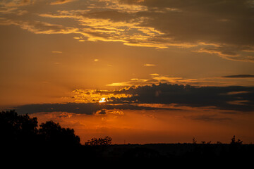 Orange sunrise on the horizon with emphasis on the sun's rays and birds in the distance. Idyllic Setting