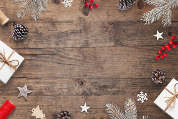 Christmas desk with festive decorations, tree branches, gifts, and copy space. Wood background with holiday atmosphere