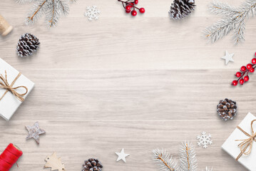 Top view flat lay Christmas composition on wooden table with festive decorations, featuring copy space in the center