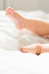 New born baby feet on white blanket on bedroom top view. Child and innocence