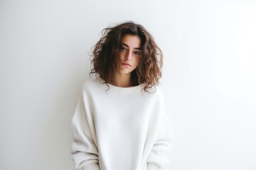 Obraz premium Woman Posing Gracefully in Front of a Clean Minimalist White Wall Generative AI