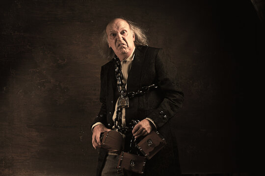 Ghost of Jacob Marley, Scrooge ex-business partner, chained with a padlock, carrying treasure chests and keys