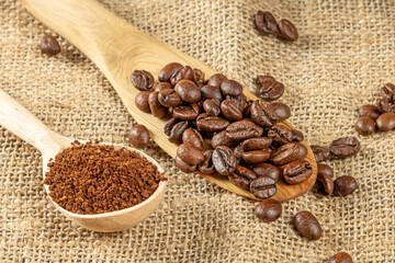 Coffee theme. Two wooden spoons with coffee beans and ground coffee granules