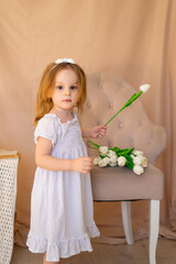 cute and funny little girl with  a tulip flower in her hands