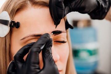 The makeup artist performs long-term eyebrow styling and paints the eyebrows. Lamination of...