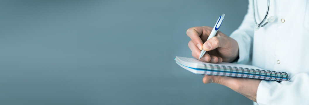 doctor holding pen with notepad