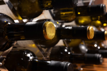 wine bottles filled with the best wine arranged in the cellar with a view of the black and gold...