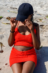 A young african lady seated on the beach sand enjoying the breeze