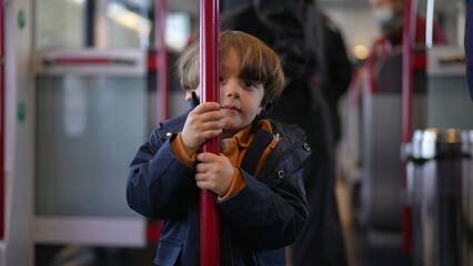 Child holding into train metal vertical bar turning in circles to pass the time while traveling...
