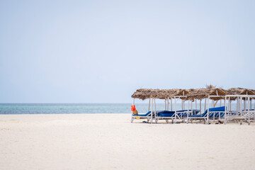 White sandy beach,turquoise ocean and deck chairs at the beach at sunny day, luxury beach house.Zanzibar,Tanzania.