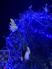 Fragment of a Christmas tree. Night sky. Holiday lights. Garland.
