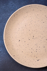 Round empty colored ceramic plate on concrete texture background