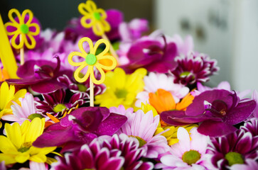 Beautiful bouquet of purple, orange, yellow and white flowers, fragment, close. High quality photo