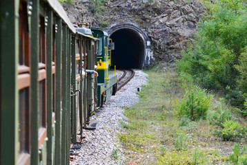 Mountain railroad with train in tunnel.