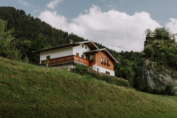 Alpine Chalet In The German Alps. Panoramic view of scenic mountain landscape in the Alps with traditional old mountain chalet and fresh green meadows in springtime.