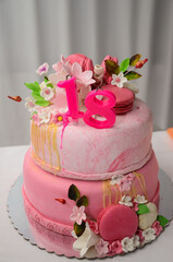 Beautiful pink cake with macarons and flowers decoration for 18th birthday