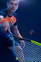 Squash player on a squash court with racket. Man athlete with racket on court with neon colors....