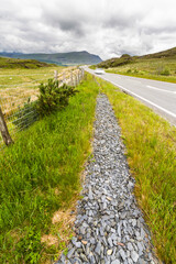 Blurred car Upland road through moorland in Eryri or Snowdonia national Park, Wales. - 679860253