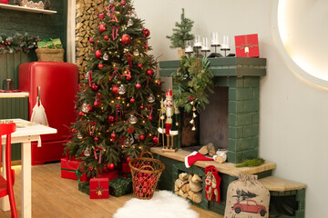 Christmas tree in a beautiful red and green kitchen. Christmas tree near the fireplace in the kitchen. beautiful christmas interior