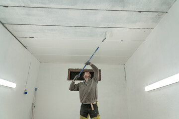 Skilled Artisan Painting Garage in Pristine White - Expert Home Improvement.