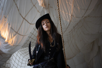 Lady pirate attacks with a saber, boarding. beautiful young brunette in a pirate costume