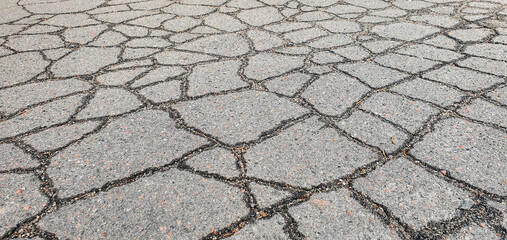 Old road with cracked damaged, destroyed, worn, broken, broken, dirty asphalt. Cracks in the...