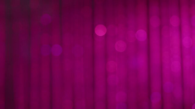 Soft focus glittering pink magenta background of twinkling jewel curtain backdrop moving organically. Genuine camera lens bokeh.