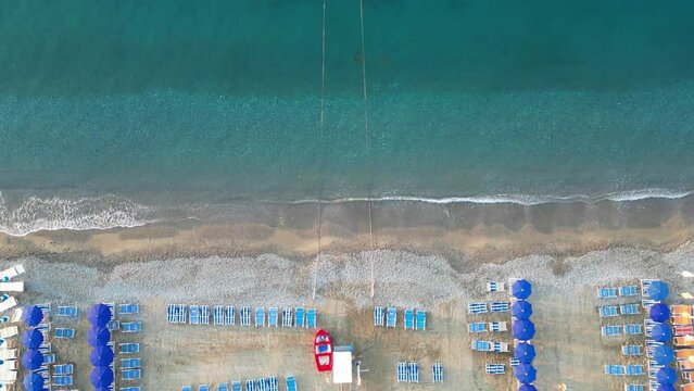 Empty beach with sun loungers and parasols on the sea coast, view from a drone.