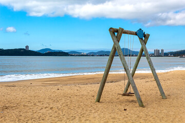 balanço de madeira com um adorne de um peixe na praia em Balneário Piçarras, Santa Catarina,...