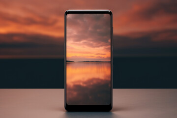 smartphone captures a tranquil sunset reflecting over calm waters, displayed on a smooth surface