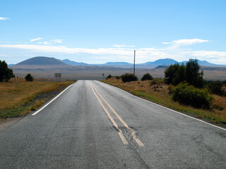 Empty rural road with perspective to the volcanic fields of Eastern New Mexico. 