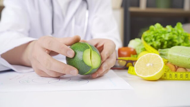 Dietician splitting an avocado in half.