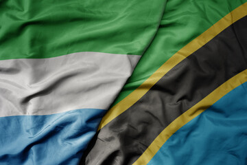 big waving national colorful flag of sierra leone and national flag of tanzania .