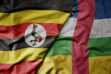 big waving national colorful flag of uganda and national flag of central african republic .