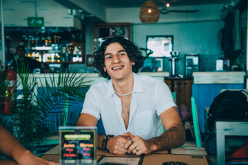Man smiling while enjoying meeting with friends in a restaurant.