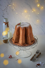 Pandoro - traditional Italian Christmas cake on a white plate with powdered sugar, Christmas tree...
