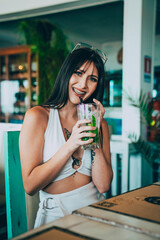 Young woman smiling while having a drink.