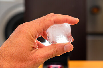  fingers an ice hand holding between the hand holding hand holding between the fingers an ice cube, solid water. the fingers an ice cube, solid water. an ice cube, solid water, solid water.