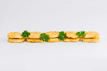 Breaded Chicken Inner Fillet, Chicken Breaded Raw Meat. Fast cooking.Breaded Chicken nuggets Fillet with salad on a White Background,food at home. Fast homemade food.Chicken breaded schnitzels.
