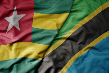 big waving national colorful flag of tanzania and national flag of togo .