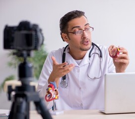 Young male doctor cardiologist recording video for his blog