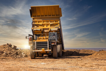 mining truck tipping the load at a diamond mine at sunset