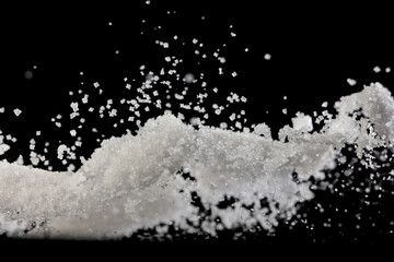 Salt powder pour fall in bowl, white Salt crystal cook abstract cloud fly. Ground salt splash in air, food object element design. Black background isolated selective focus blur