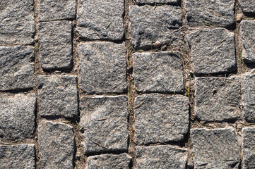 Grey color cobblestone pavement texture closeup shot, view from above.