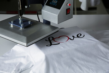 Printing logo. Heat press with t-shirt on white table, closeup