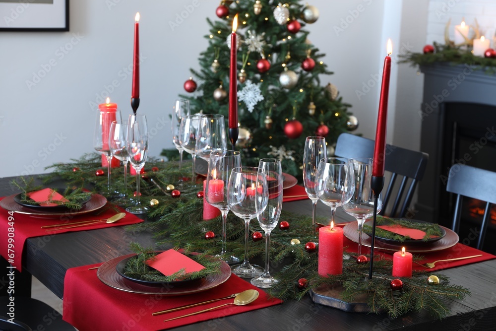 Poster elegant christmas table setting with dishware and burning candles in festively decorated room