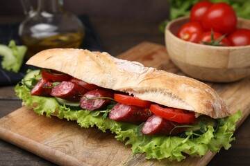 Delicious sandwich with sausages and vegetables on table, closeup